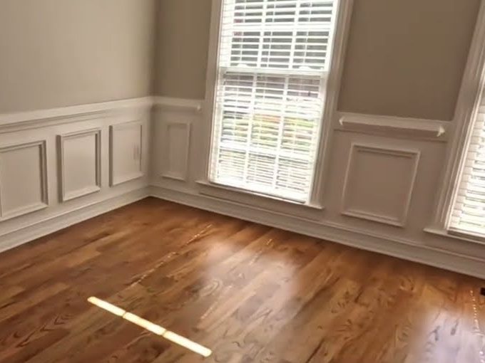 Golden Oak stained red oak floor beside white wainscoting and a window, refinishing in Acworth, GA