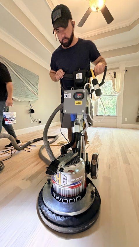The Hardwood Guys crew running a floor sander during a maintenance visit