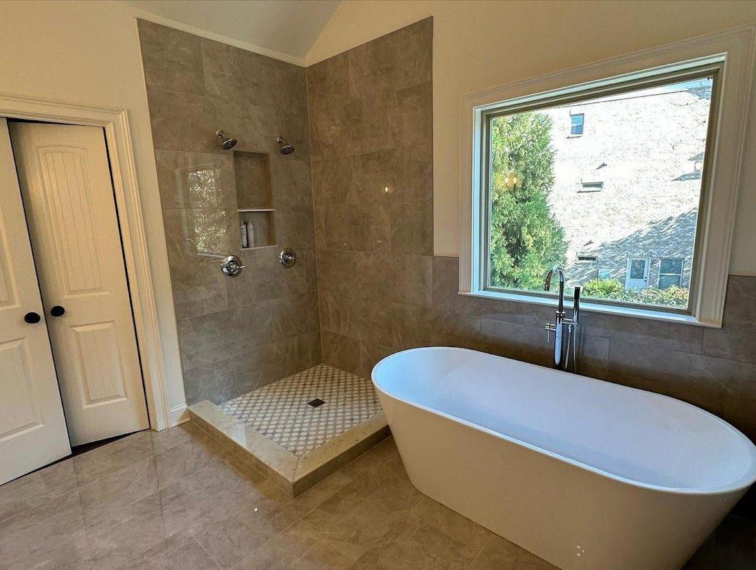 Tile walk-in shower and freestanding tub in a primary bathroom remodel