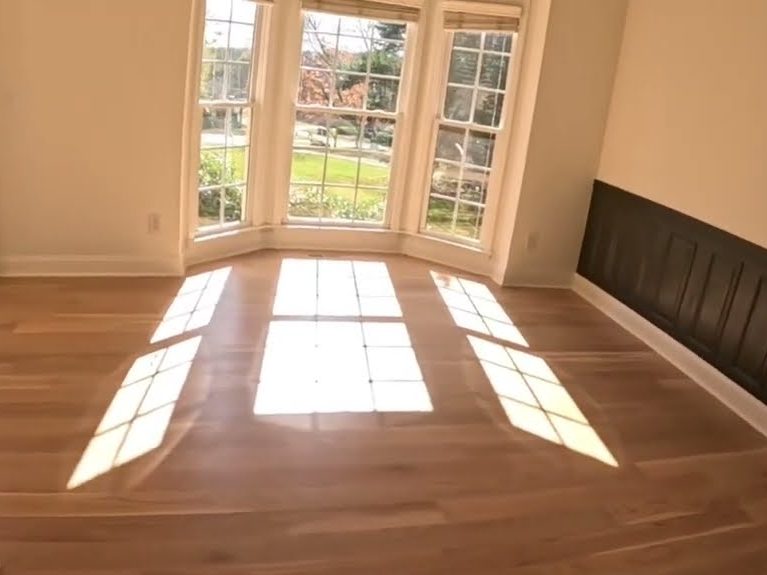 Sunlit wide plank white oak floor in a room with a bay window, hardwood installation in Cumming, GA