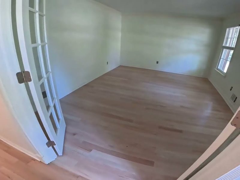 Light oak floor in an empty room with French doors, refinishing in Marietta, GA