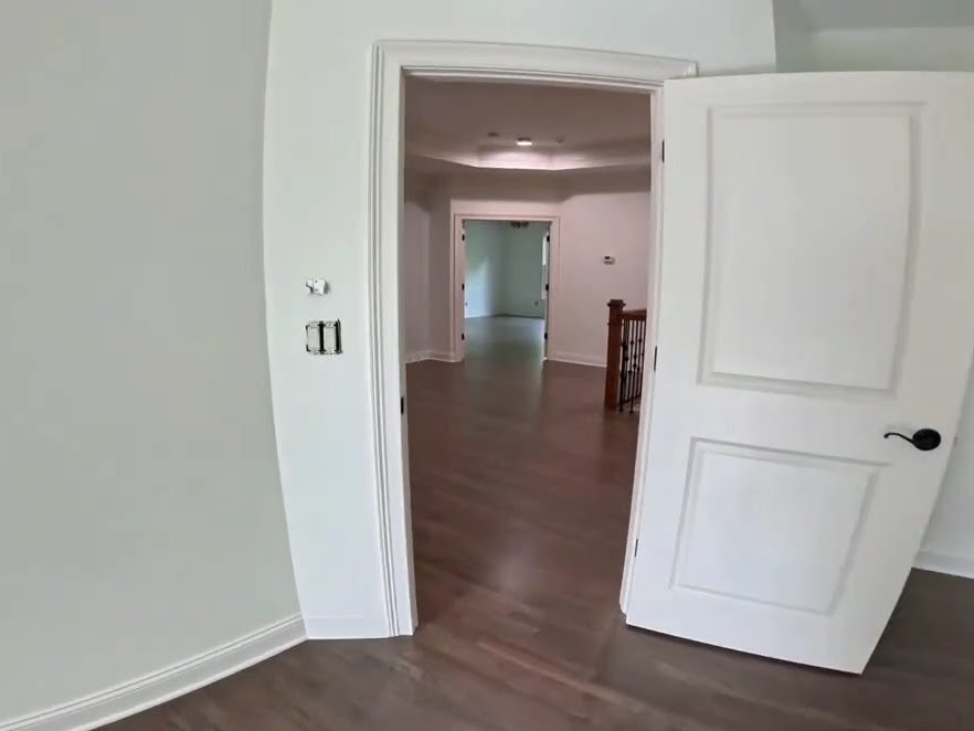 Open doorway to a hallway with a Classic Gray stained red oak floor, refinishing in Roswell, GA
