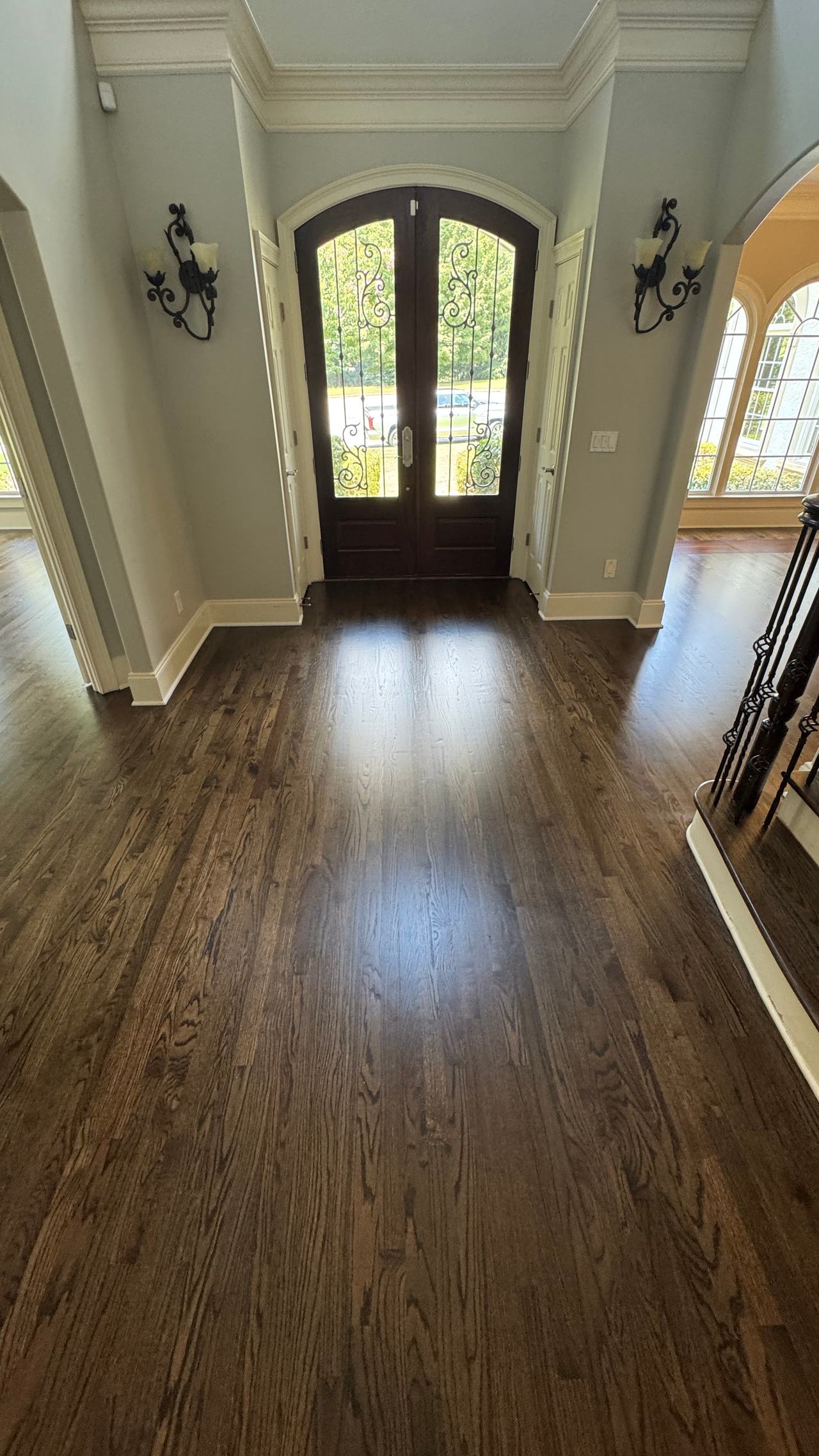 Foyer with red oak hardwood floor in Dark Walnut stain and matte finish, arched double front door with wrought-iron glass inserts