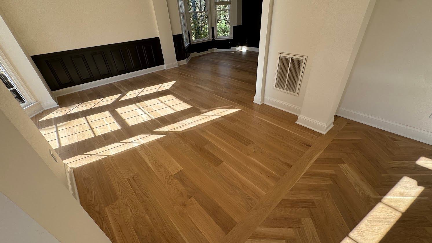 Newly installed white oak hardwood flooring with a herringbone inlay border in a North Metro Atlanta home