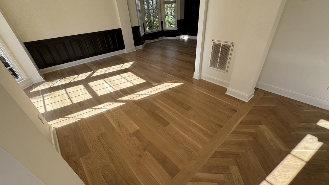 Finished white oak floor with a herringbone inlay border in a North Metro Atlanta home
