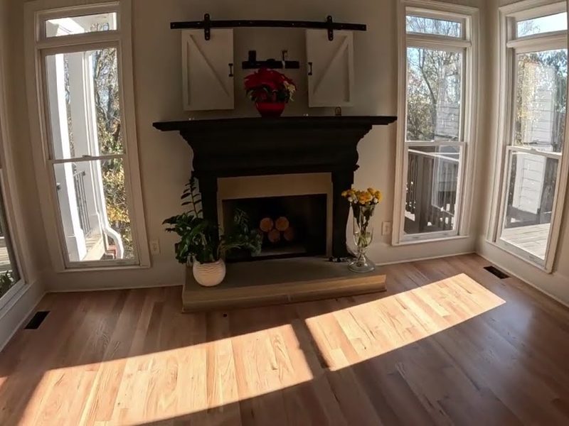 Sunlit natural-toned red oak floor in front of a fireplace, Bona Mega One refinishing in Woodstock, GA