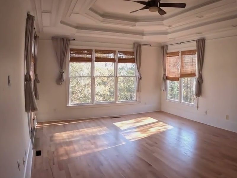 Natural-toned red oak floor in a room with sunlit windows and a tray ceiling, Bona Mega One refinishing in Woodstock, GA